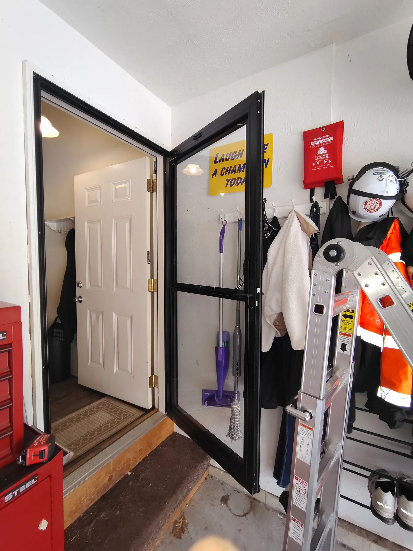 Installed black storm door open to show its swing and frame