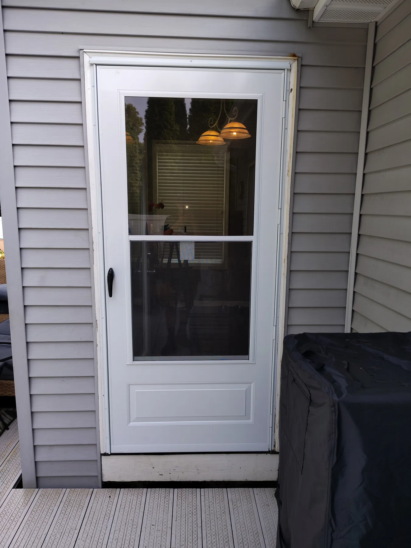 Completed white storm door installation viewed from outside