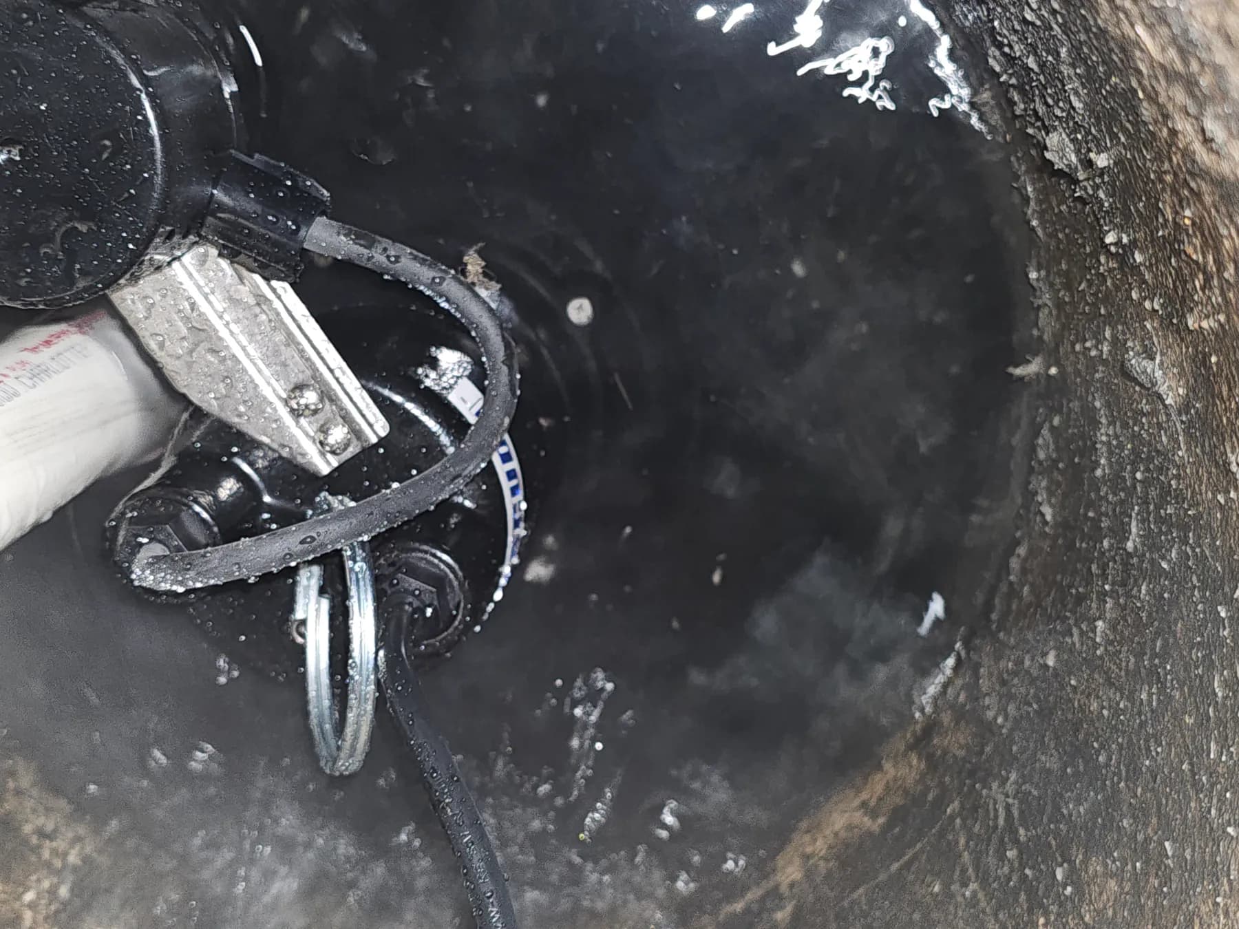 Close view of sump pump, float switch, and discharge pipe